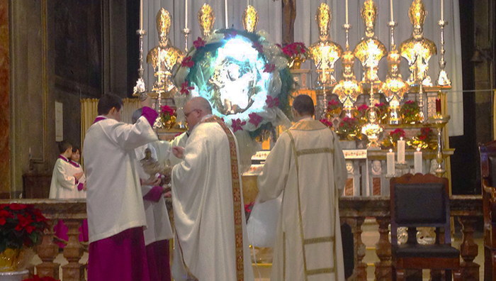 Gesù bambino in una sfera sopra l'altare. In Collegiata la Messa di Natale. Foto